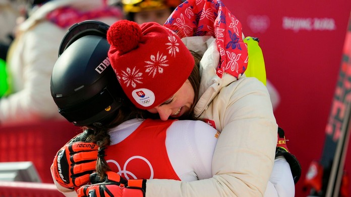 Olympijská víťazka Petra Vlhová sa objíma so Sarou Hectorovu po slalome na ZOH 2022.