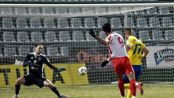 Na snímke uprostred hráč ŠKF Sereď Roko Jureškin strieľa gól brankárovi MFK Zemplín Michalovce Andrijovi Kožucharovi.