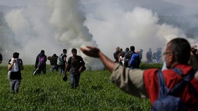 Na snímke macedónska polícia zakročila proti skupine asi 500 migrantov, ktorí sa v Grécku pokúsili preraziť hraničné oplotenie v