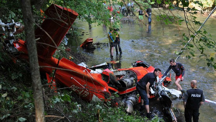 Na snímke polícia, vyšetrovatelia a záchranári skúmajú spadnutý vrak vrtuľníka