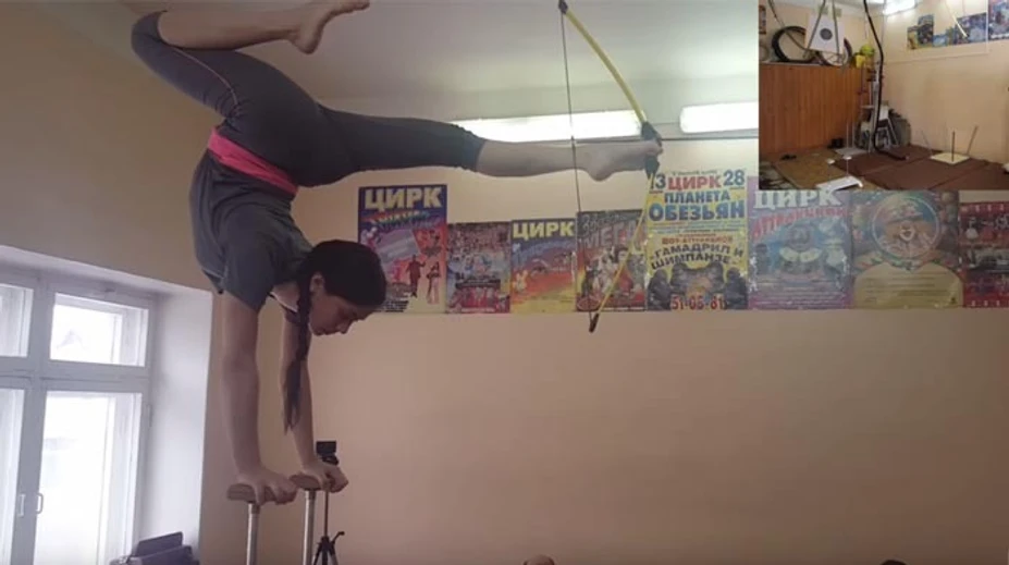 Len 12-ročná Ruska má nevídaný talent. Stojí na rukách a nohami strieľa z luku