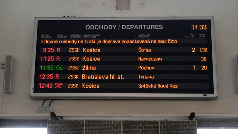 Informačná tabuľa o meškaní vlakov na železničnej stanici v Trenčíne.