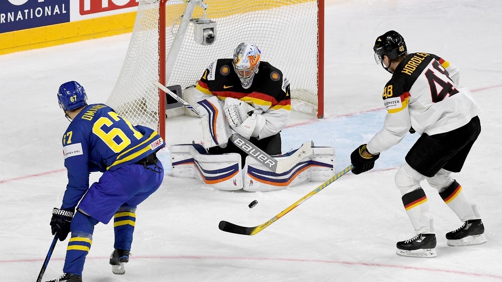 Nemecký brankár Thomas Greiss blokuje strelu Švéda Linusa Omarka.