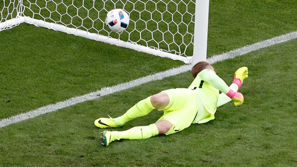 Anglický brankár Joe Hart inkasuje gól po priamom kope Walesana Garetha Balea.