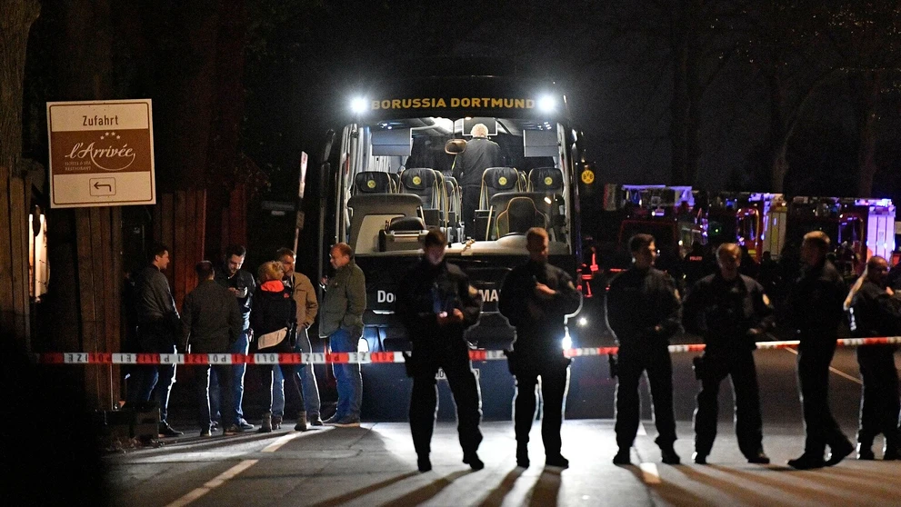 Policajti stoja pred autobusom Borussie Dortmund, pri ktorom vybuchli nálože pred štvrťfinále LM proti Monacu.
