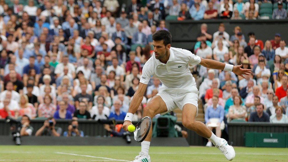 Novak Djokovič odvracia úder Adriana Mannarina v osemfinále Wimbledonu.