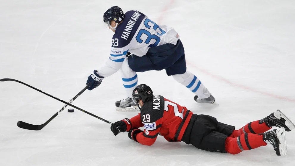 Nathan Mackinnon (dole) z Kanady sa snaží v zápase MS 2017 zastaviť Fína Markusa Hannikainena.