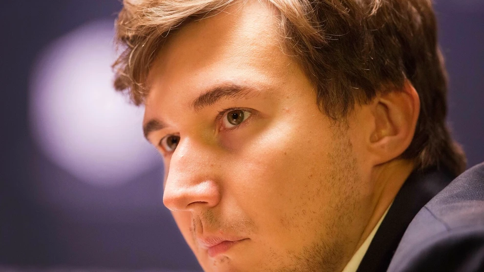 Nórsky úradujúci majster sveta Magnus Carlsen ťahá bielou vežou a berie čiernu figúrku vyzývateľovi Sergejovi Karjakinovi počas 