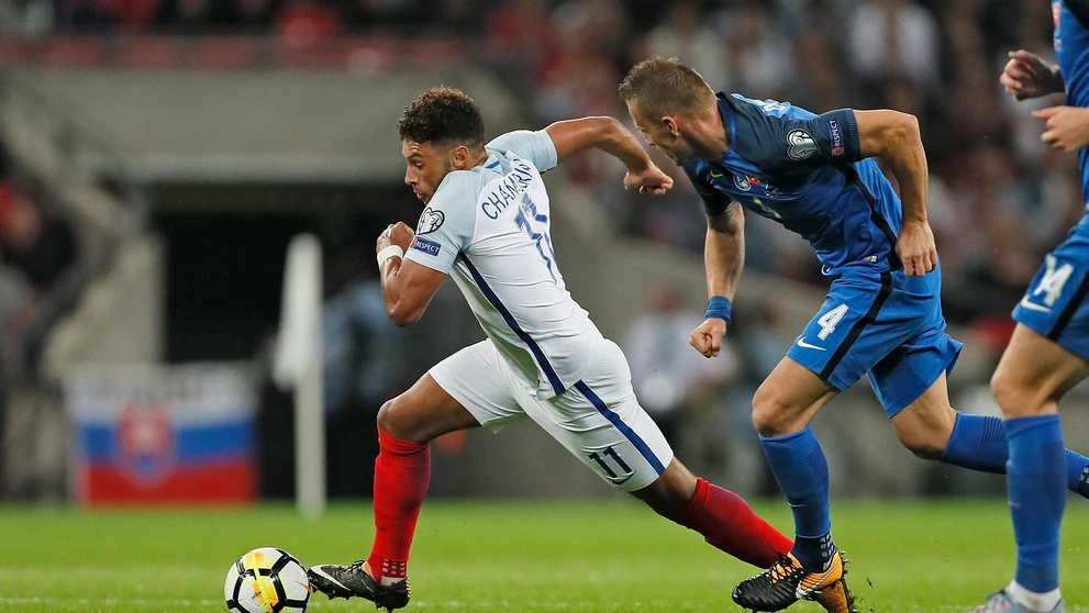 Alex Oxlade-Chamberlain (vľavo) uteká s loptou pred Jánom Ďuricom v kvalifikačnom zápase MS proti Anglicku.