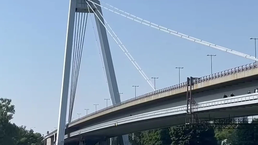 Muž sedí na zábradlí Mosta SNP