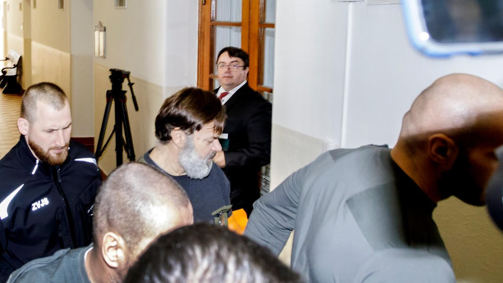 Dušan Dědeček prichádza v sprievode členov Zboru väzenskej a justičnej stráže prichádza do súdnej siene na Okresnom súde Bratislava I v stredu 25. januára 2023.