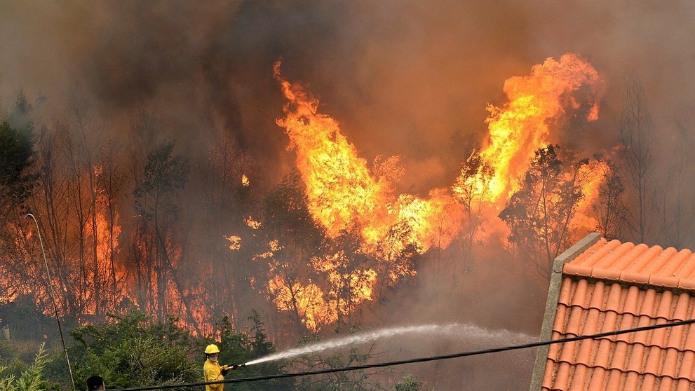 Šľahajúce plamene a bezmocný požiarnik.