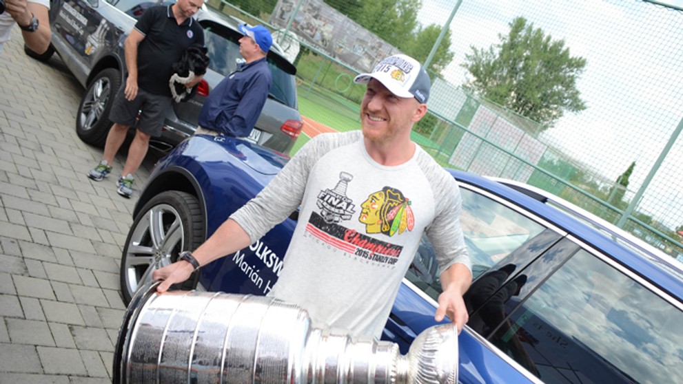 Útočník Chicago Blackhawks Marián Hossa nesie Stanleyho pohár pre víťaza NHL.