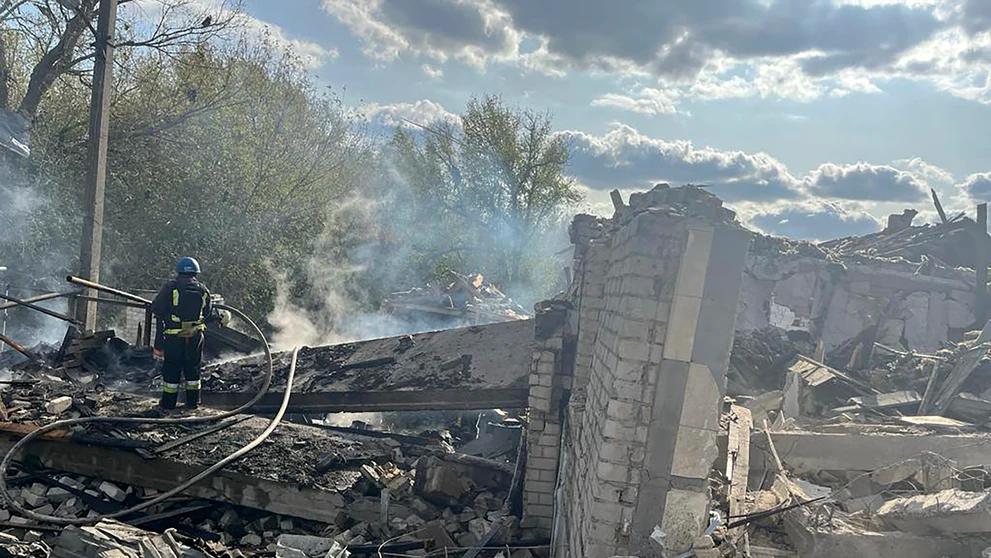 Na snímke hasiči hasia požiar po ruskom raketovom útoku na dedinu Hroza v Charkovskej oblasti