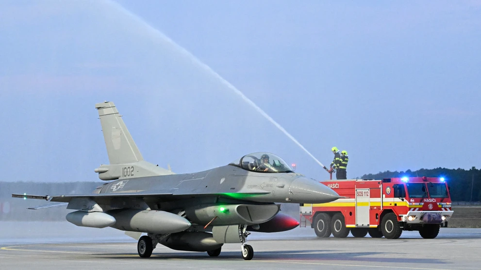Jedna z dvoch stíhačiek F-16 symbolicky prechádza tzv. slávobránou z hasičských striekačiek v priestoroch Leteckej základne Malacky-Kuchyňa.