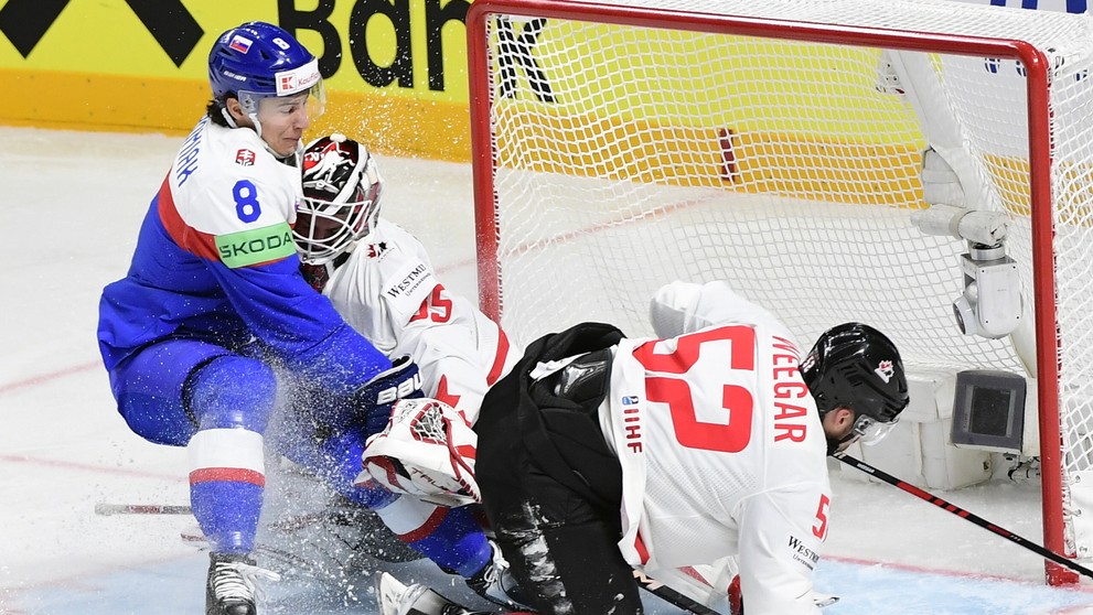 Na snímke uprostred brankár Kanady Samuel Montembeault, vpravo jeho spoluhráč a obranca MacKenzie Weegar, vľavo slovenský útočník Martin Chromiak.