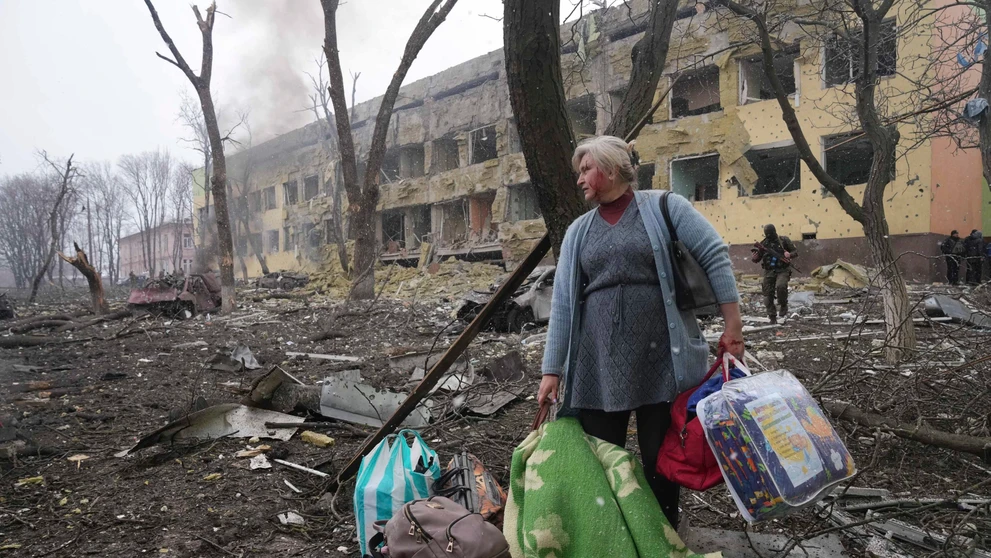 Žena pred bombami zničenou pôrodnicou v Mariupole.