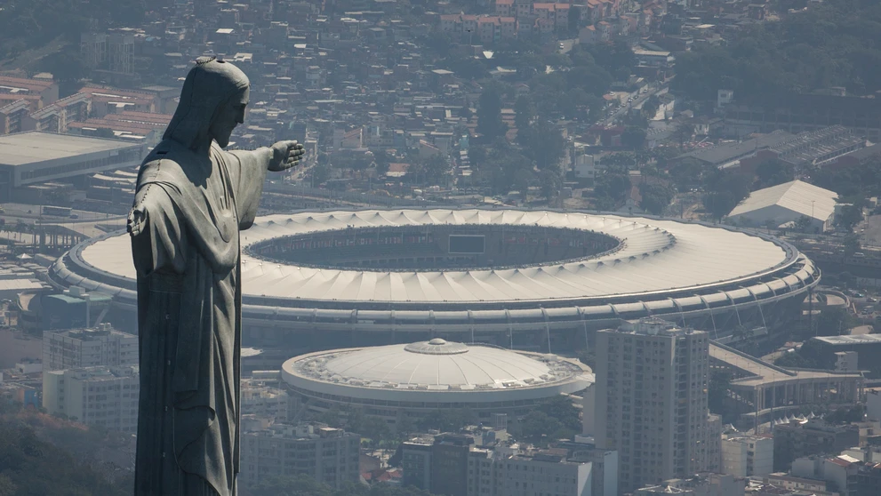 Na snímke gigantická socha Krista Spasiteľa, ktorá je umiestená na vrchu Corcovado, a za ňou štadión Maracaná.