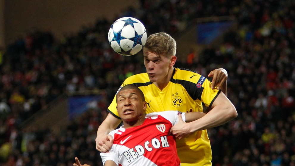 Matthias Ginter (vpravo) z Dortmundu hlavičkuje pred Kylianom Mbappém z Monaca v odvete štvrťfinále LM.