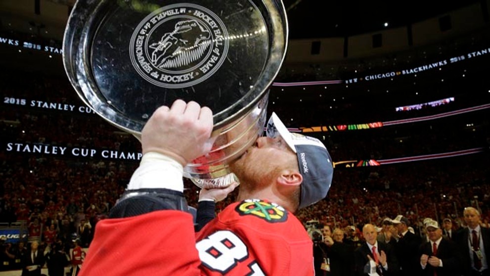 Marián Hossa zdvíha tretíkrát nad hlavu Stanleyho pohár s Chicagom Blackhawks.