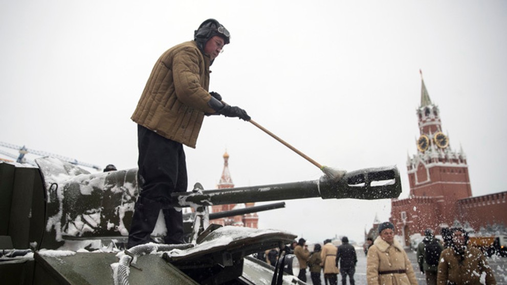 Vojak ruskej armády v dobovej uniforme odstraňuje sneh z tanku z II. svetovej vojny´. 
