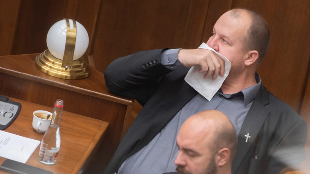 Peter Krupa si prekrýva tvár papierovou vreckovkou a dole Andrej Medvecký (obaja ĽSNS).