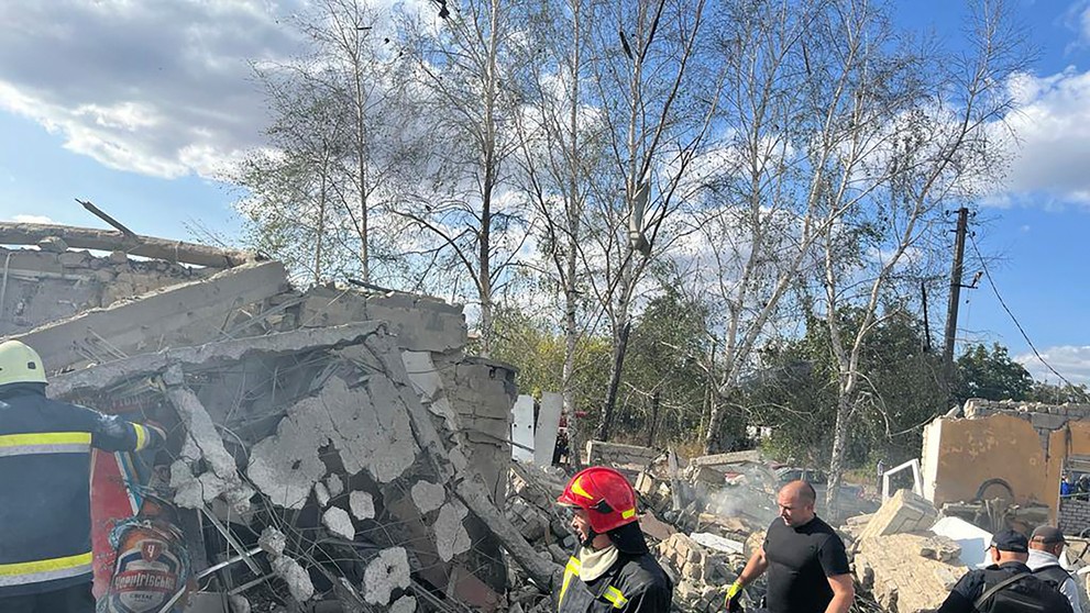 Na snímke hasiči hľadajú obete po ruskom raketovom útoku na dedinu Hroza