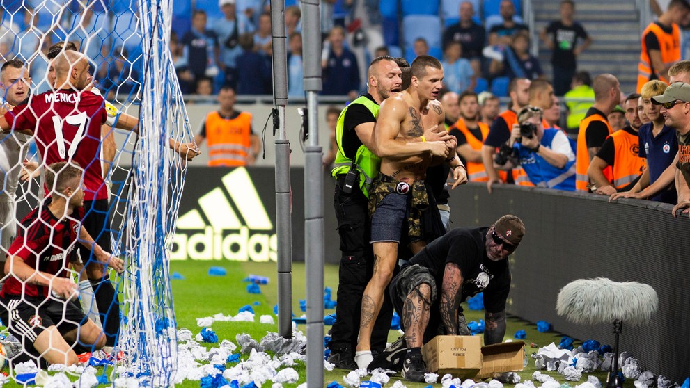Na snímke vpravo jeden z fanúšikov Slovana vbehol na ihrisko a pridal sa k roztržke hráčov oboch mužstiev.