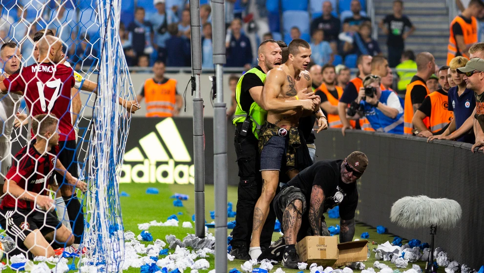 Na snímke vpravo jeden z fanúšikov Slovana vbehol na ihrisko a pridal sa k roztržke hráčov oboch mužstiev.
