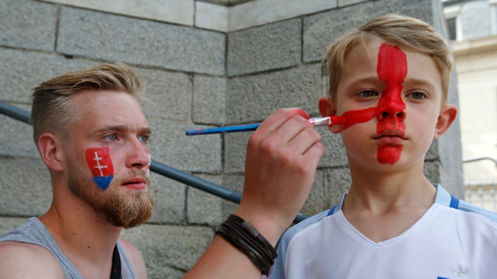 Muž na ulici maľuje malého fanúšika Anglicka.