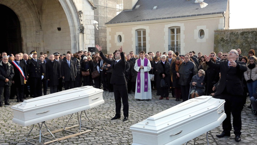 Nosiči vypúšťajú holubice počas pohrebu dvoch sestrier Marion a Anny Petardových vo francúzskom meste Blois.