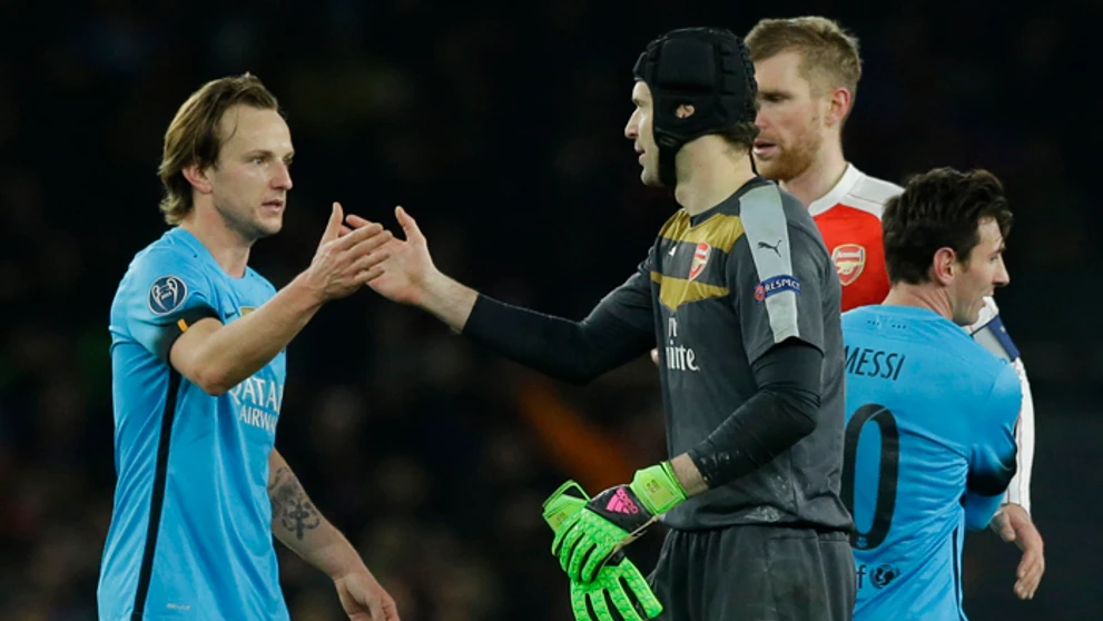 Brankár Arsenalu Petr Čech si podáva ruku s Ivom Rakitičom, v pozadí Lionel Messi.