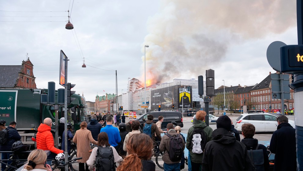 Ľudia sledujú požiar budovy.