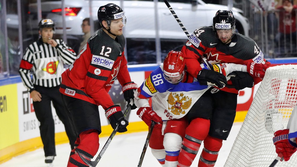 Dvojica Kanaďanov Colton Parayko (vľavo) a Marc-Edouard Vlasic atakuje v semifinále MS 2017 Rusa Nikitu Kučerova (v strede).