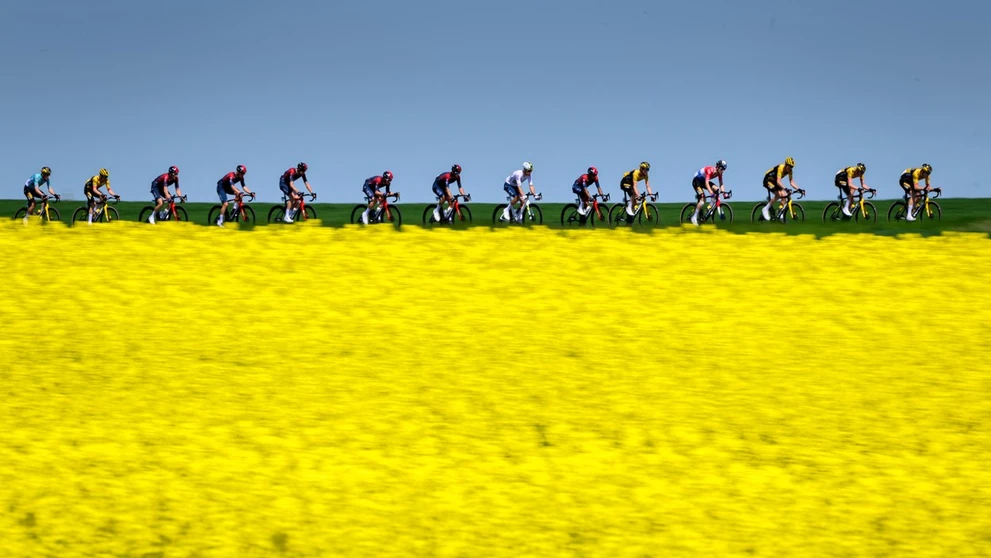 Skupina jazdcov prechádza okolo švajčiarskej dediny Echallens počas 4. etapy cyklistických pretekov Tour de Romandie.