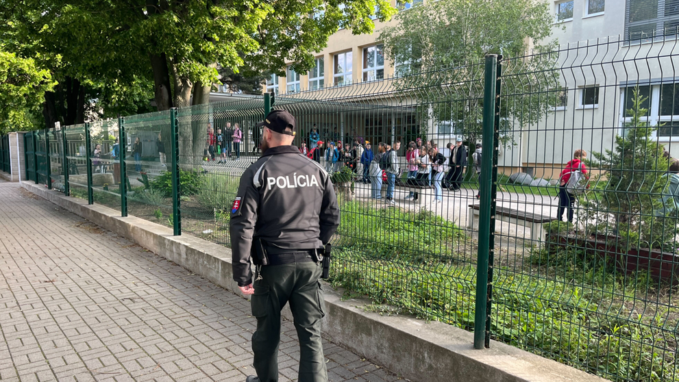 Policajt hliadkuje pred školou v Ivanke pri Dunaji.