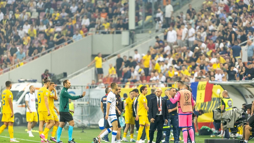 Hráči Rumunska a Kosova opúšťajú hraciu plochu štadióna.