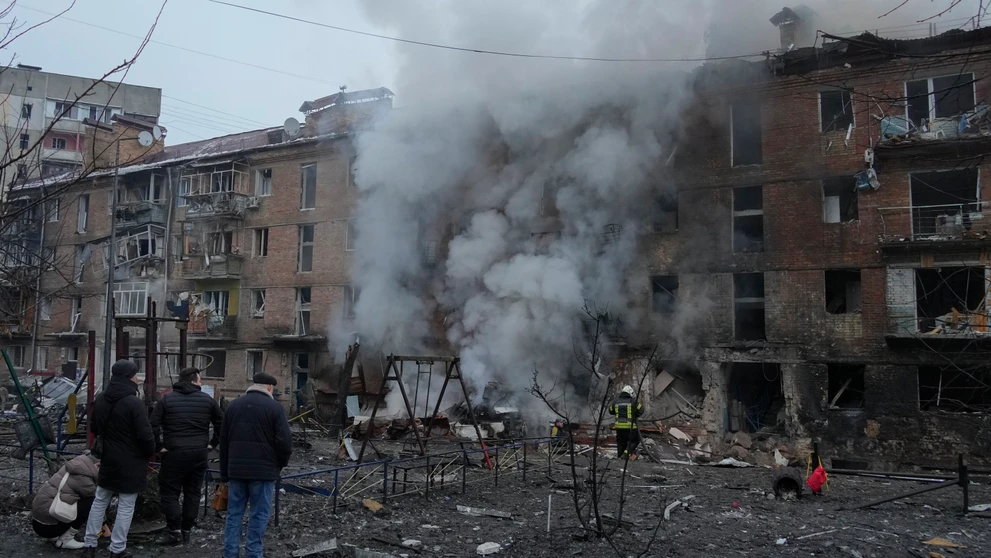 Ľudia si prezerajú materiálne škody na obytnej budove po ruskom raketovom útoku v Kyjeve.
