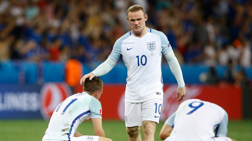 Anglický futbalista Wayne Rooney utešuje svojich spoluhráčov po osemfinálovej prehre s Islandom na ME.