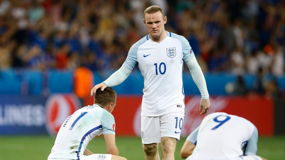 Anglický futbalista Wayne Rooney utešuje svojich spoluhráčov po osemfinálovej prehre s Islandom na ME.