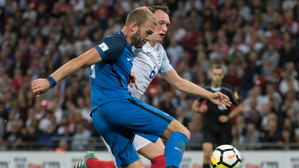 Adam Nemec sa snaž prepáliť loptu cez Phila Jonesa v zápase kvalifikácie MS proti Anglicku.
