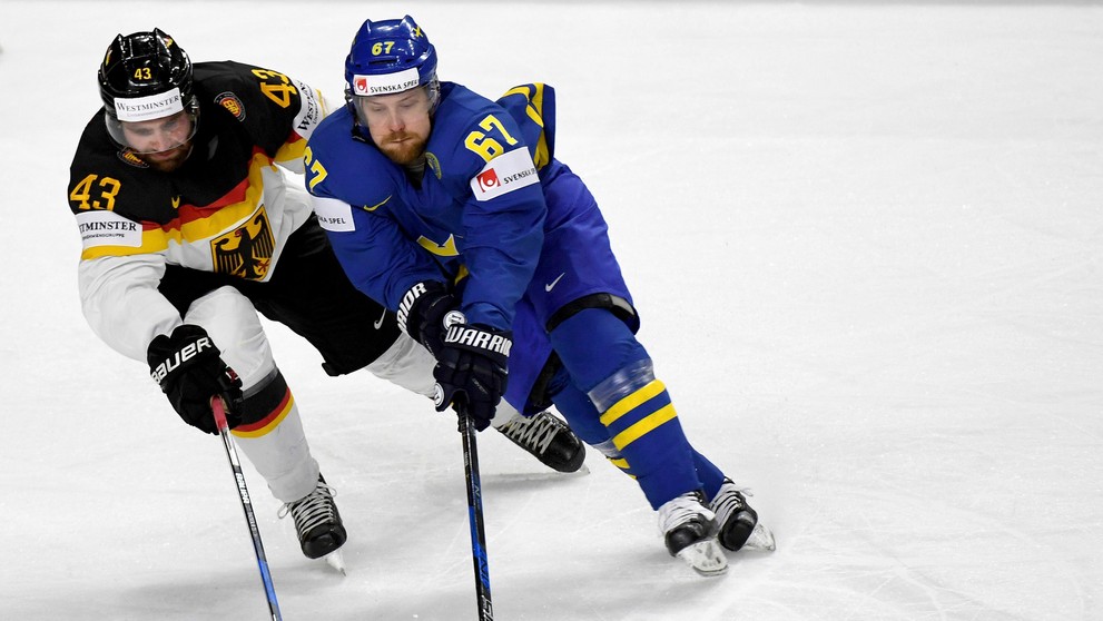 Nemec Gerrit Fauser a Švéd Linus Omark v súboji o puk.