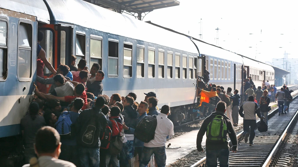Migranti sa snažia nastúpiť do vlaku v Budapešti.