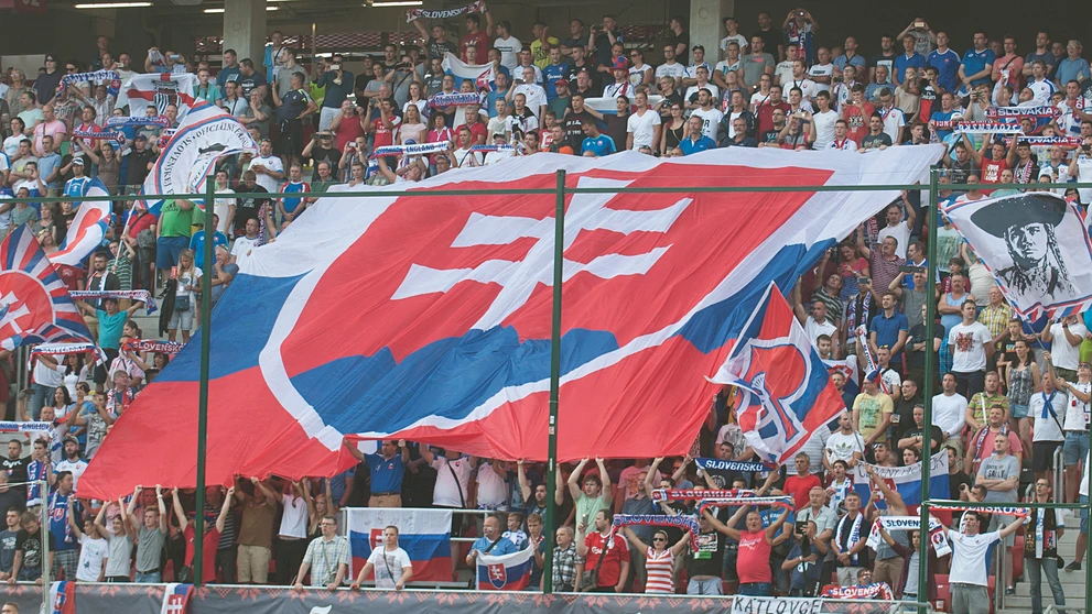 Slovenskí priaznivci so štátnou vlajkou počas duelu kvalifikácie MS 2018 proti Anglicku.