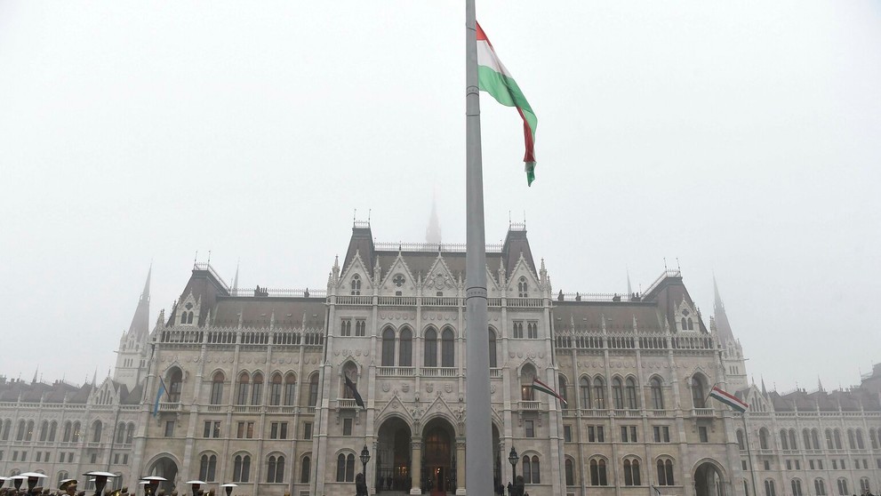 Maďarská štátna vlajka veje na pol žrde pred budovou parlamentu.