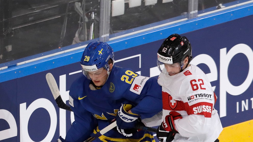 William Nylander (vľavo) zo Švédska si prikrýva puk pred Švajčiarom Denisom Malginom vo štvrťfinále MS 2017.