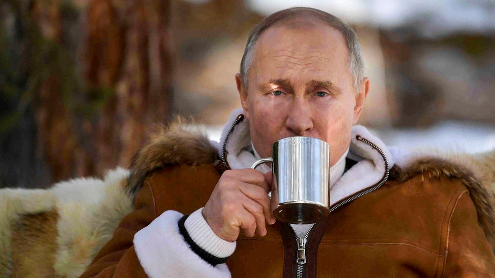 Ruský prezident Vladimir Putin pije zo šálky v rámci prestávky počas víkendovej návštevy tajgy na Sibíri 21. marca 2021..jpg