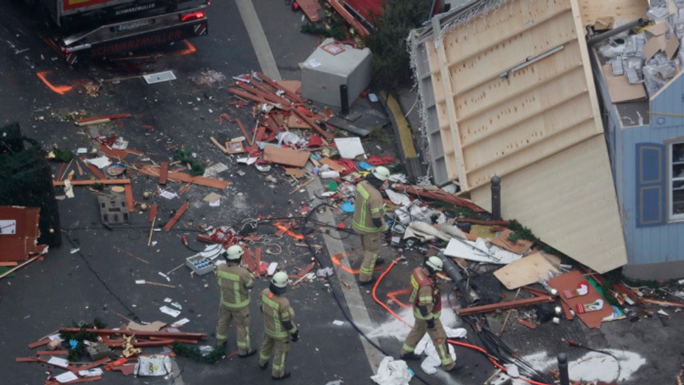 Hasiči prehľadávajú miesto útoku kamiónom na berlínskych vianočných trhoch.
