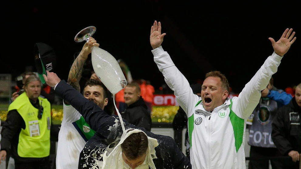 Portugalčan Vieirinha leje pivo na trénera Wolfsburgu Dietera heckinga po výhre vo finále Nemeckého pohára.