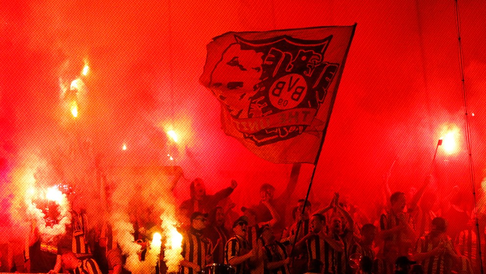 Priaznivci Dortmundu so svetlicami počas duelu LM v Lisabone proti Sportingu.